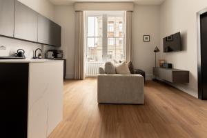 a living room with a couch and a kitchen at Moment Blythswood St in Glasgow