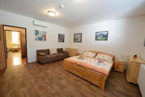 オストラヴァにあるŠkolící středisko ABENA s ubytovánímのベッドルーム1室(ベッド1台、ソファ付)