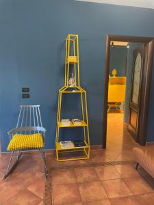 ein gelbes Regal und ein Stuhl in einem Zimmer in der Unterkunft Villa Kora - elegance and comfort in Reggio Calabria in Reggio di Calabria + 13 Fotos