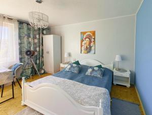 a bedroom with a white bed with a blue blanket at MAREA rooms in Jantar