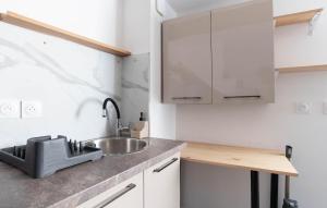 a kitchen with a sink and white cabinets at Studio Coeur De Ville in Solliès-Pont
