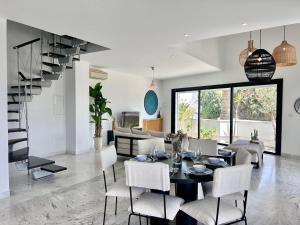 a living room with a table and chairs and a staircase at Appartement Casa bloom in Gammarth