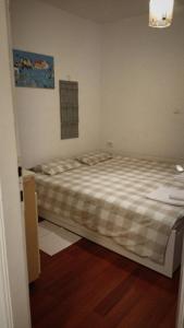 a bedroom with a large bed with a plaid blanket at Pipilota in Rijeka