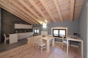 a kitchen and dining room with a table and chairs at Zoncolan Apartments in Sùtrio
