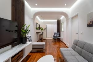a living room with a couch and a television at Magnus Apollo in Thessaloniki