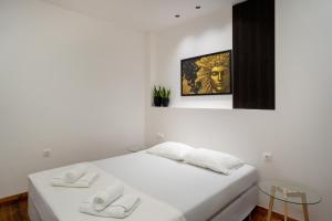 a white room with a bed with two white towels at Magnus Apollo in Thessaloniki