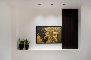 a white wall with a picture of a bust on it at Magnus Apollo in Thessaloniki