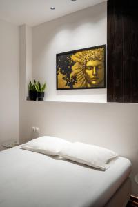 a bedroom with a white bed with a statue on it at Magnus Apollo in Thessaloniki +25 photos