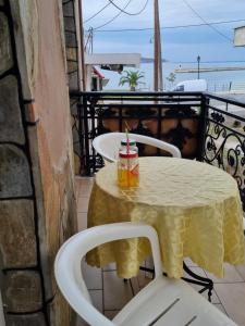 a table with a drink on a balcony with the ocean at Vasilis & Nikolas Studios in Limenas