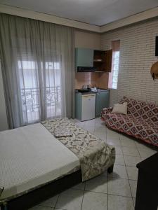 a bedroom with a bed and a couch in it at Vasilis & Nikolas Studios in Limenas
