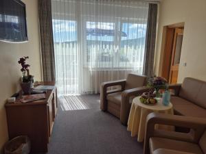 a living room with a couch and a table at Panorama Hotel Oberwiesenthal im Erzgebirge in Kurort Oberwiesenthal