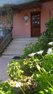 - un bâtiment avec des escaliers et des fleurs devant dans l'établissement Delle Rose, à Cefalù