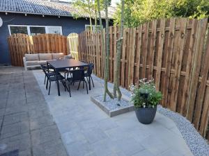 a patio with a table and chairs and a fence at The Cozy Cottage in Hirtshals +17 photos