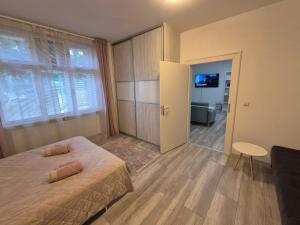 a bedroom with a bed and a room with a tv at Apartman Centrum Mudronova in Košice