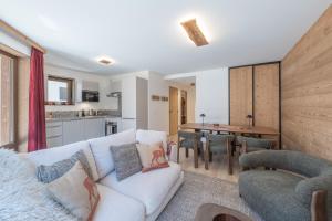 a living room with a couch and a dining room at Le Refuge du Pic in L'Alpe-d'Huez