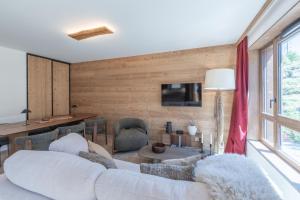 a living room with a white couch and a table at Le Refuge du Pic in L'Alpe-d'Huez