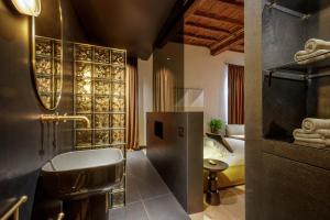 a bathroom with a tub and a sink in a room at Daplace - Palazzo Serpe Suites near Colosseum in Rome