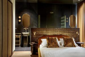 a bedroom with a bed and a bathroom with a sink at Daplace - Palazzo Serpe Suites near Colosseum in Rome