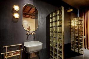 a bathroom with a sink and a mirror at Daplace - Palazzo Serpe Suites near Colosseum in Rome