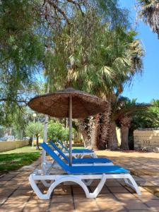 a pair of blue chairs and an umbrella at Location résidence macael roquetas de mar in Roquetas de Mar