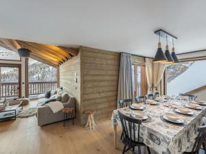 ein Esszimmer mit Tisch und Couch in der Unterkunft Chalet moderne 5 chambres à Méribel, proche pistes - FR-1-565-72 in Les Allues
