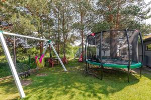 un grupo de columpios en un patio en Poilsio nameliai Gulbes takas, en Šventoji