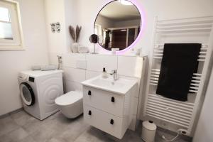 トッセンスにあるWatt n` Kokolores - Ferienhaus mit Terrasse und Infrarotsaunaのトイレ、洗面台、鏡のあるバスルーム +16枚の写真