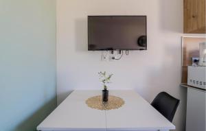 a white table with a vase on top of it at Jolie Maison Proche Plage in Le Crotoy