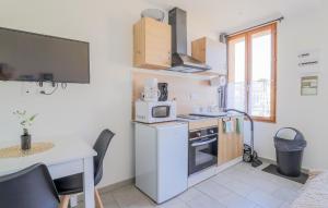 a kitchen with a white refrigerator and a table at Jolie Maison Proche Plage in Le Crotoy