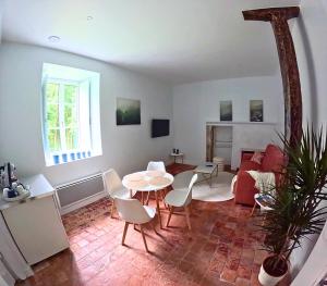 ein Wohnzimmer mit Sofa, Tisch und Stühlen in der Unterkunft Gîte Eugène Süe - cuisine fermée in Magny