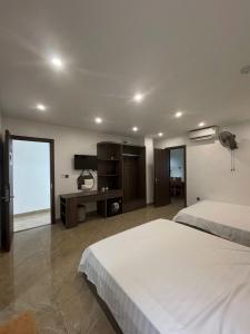 a hotel room with two beds and a television at Sunrise Hotel Thiên Cầm in Hà Tĩnh