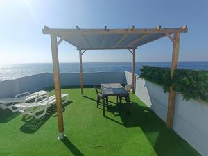 El EscobonalStudio avec terrasse et vue mer的阳台凉亭配有桌椅