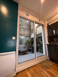 a kitchen with a sliding glass door to a patio at Cosy Appart Hotel Levallois-Perret 92 in Levallois-Perret