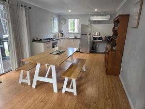 a kitchen with a wooden table and a table and chairs at 75 Peace Street in Denmark