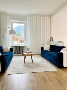 a living room with two blue couches and a table at Historische Altbau Suite in Bad Mitterndorf
