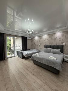 a bedroom with two beds and a chandelier at Hotel Kalyan & Spa in Chişinău +118 photos