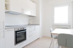 a kitchen with white cabinets and a table and a window at Stadium Residence in Brescia +85 photos