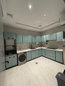 ジッダにあるSelf Check-In Apartments by MehadStayの青いキャビネットと食器洗い機付きの広いキッチン