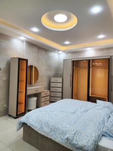 a bedroom with a large bed with a blue blanket at Monani in Amman