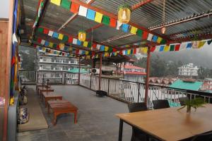 a restaurant with tables and flags hanging from the ceiling at White Mountain By Pahadi Adda in McLeod Ganj