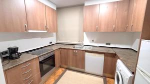 una piccola cucina con armadi in legno e lavandino di SANTA BARBARa a Roses Altre 28 foto