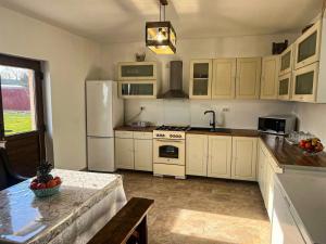 a kitchen with white cabinets and a table in it at Pensiunea Salcioara in Salcioara