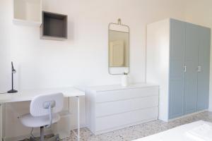 a white desk with a chair and a mirror at Stadium Residence in Brescia