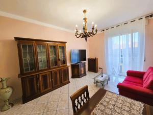 een woonkamer met een rode bank en een kroonluchter bij Appartamento Galileo Ferraris, in Vercelli