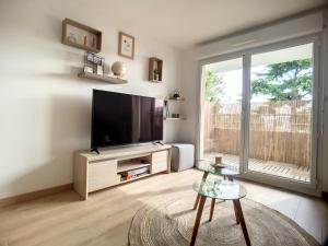 a living room with a large flat screen tv at La Brioch'inn - Appartement Moderne et Lumineux - Proche FAC ITC Rabelais in Saint-Brieuc