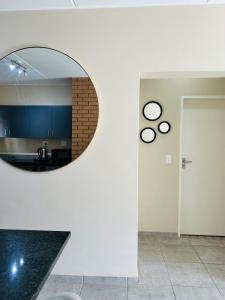 uno specchio rotondo su una parete in una stanza di Stunning modern 2 bedroom apartment in Waterfall Ridge a Midrand