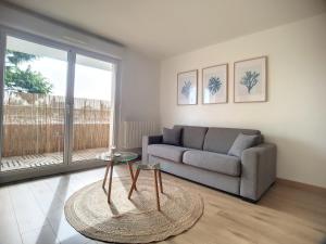 a living room with a couch and a table at La Brioch'inn - Appartement Moderne et Lumineux - Proche FAC ITC Rabelais in Saint-Brieuc