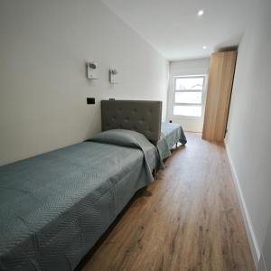 een slaapkamer met een bed en een houten vloer bij Manisa I in Ribadeo +11 foto's