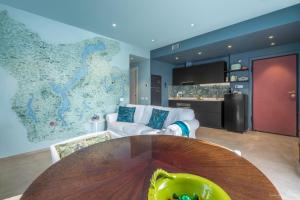 a living room with a table and a map on the wall at Draisina Bike Apartments DUE in Oleggio Castello