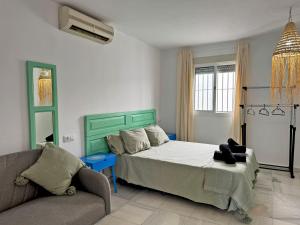 a bedroom with a bed and a couch in it at Casa Las Cumbres I - Ole Solutions in El Puerto de Santa María